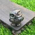 Detailed 3.5cm dark natural stone owl carving figurine on wooden base with green background - Sesame Stone