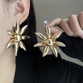 Close-up of a large gold floral stud earring worn by a model in a minimalist style - E3252 Polished Sunflower Style / Gold