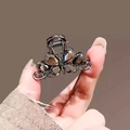 Detail of a small metal hair claw clip featuring grey crystal flowers held by a hand - 15# Crystal Butterfly Claw (Approx. 4CM)