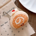 Close-up of a soft plush Swiss roll cake keychain with a cute embroidered smiley face - Swiss Roll Pendant