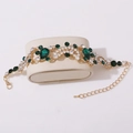 Close-up of bridal crystal bracelet with green teardrop stones and lobster clasp - Bracelet / Gold/Green