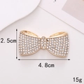Macro detail of a 4.8cm zinc alloy bow charm with white rhinestones on golden metal base - Alloy / D228 Plain Bow