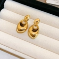 Minimalist gold irregular oval metal stud earrings displayed in a soft jewelry box - Gold