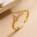 Dettaglio anello a corona placcato oro 18K con zirconi su uno sfondo caldo e materico - Aperto Regolabile / Stile Corona con Zirconi a Strati Semplice (13313)