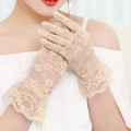 Detail of beige floral lace gloves featuring elegant ruffled cuffs for weddings - Nude