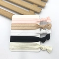Flat lay of five knotted elastic hair ties in pastel colors on a white display card - Style 3 (Pink Brown Black White)