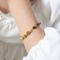 Handmade gold braided bracelet featuring natural brown and black beads on a model's wrist - Natural Stone Bracelet (E497) / 18cm / Brown