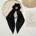 Detail of elegant black satin ribbon scrunchie on a decorative stone tray with props - Black
