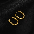 Close-up of golden beaded oval hoop earrings on a black silk textured background - Oval Beaded / Gold
