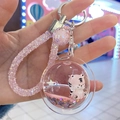 Detailed close-up of a pink liquid tiger keychain with flowing glitter and a braided strap - Planet