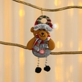 Dettaglio dell'orso natalizio appeso con cappello a quadri e zampe di perline - Orso