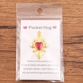 Golden heart pocket hug pendant with red enamel on a white greeting display card - Gold Border Red Heart Charm