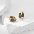 Macro shot of gold hoop earrings with pavé-set blue zircon stones and snap closure - Dark Blue Zirconia