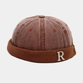 Detail of retro brown brimless hat with corduroy edge and silver metal R letter charm - Tan