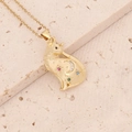 Macro detail of gold cat pendant with colorful gemstones and moon star patterns - Star Moon Cat