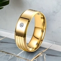 Close-up of a gold titanium steel ring with a single inset diamond and grooved details - Size 7 / Gold
