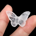 Polished transparent quartz crystal butterfly stone carving held between two fingers - White Crystal