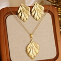 Golden leaf necklace and earrings set displayed on a premium wood tray liner - Gold Leaf Texture Jewelry Set