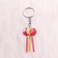 Porte-clés ballon en acrylique avec pompons rose et jaune sur fond de fausse fourrure - Ballon à Pompons