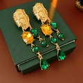 Dettaglio di orecchini vintage dorati con gemme ovali gialle e a goccia verdi su scatola - Oro-Verde (Perno in argento)
