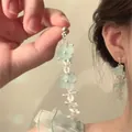 Detail of light blue acrylic flower tassel earrings worn with an elegant silver needle drop - 7# Silver Earring Post-Silver-Blue