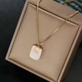 Minimalist gold necklace with square white shell pendant featuring a metal letter D - Letter D White Shell
