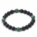 Dettaglio di perle di lava nera da 8 mm e pietre di malachite verde su un bracciale - Malachite e Pietra Smerigliata