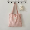 Detail of pink bubble crepe tote bag with rabbit patterns hanging on a metal hook - Skateboard Rabbit