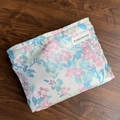 Floral fabric storage bag in beige with pink and blue patterns on dark wood background - Blue Pink Plum