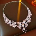 Dettaglio macro di una collana vintage con cristalli rosa su espositore in pelle - Argento-Rosa