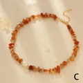 Close-up of orange gemstone beaded necklace with white pearl on silk fabric - Red Aventurine
