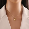 Detail of golden balloon-style letter F pendant necklace on a bean chain for women - Letter F