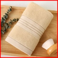Beige cotton towel with brown stripes on a wooden tray for a cozy spa bathroom vibe - Cotton Gold Border Cream (Towel)