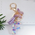 Detail of resin letter F keychain with purple butterfly charm and colorful sequins - Letter F