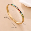 Dettaglio del bracciale in acciaio dorato con diametro interno di 5,9 cm e gemme colorate - Oro