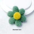 Nahaufnahme einer 6 cm großen handgefertigten Wollfilzblume in Grün und Gelb für Bastelarbeiten - Brosche Stil / Grün