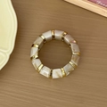Détail des perles en résine marbrée crème et intercalaires en métal doré sur bracelet - Blanc Lait