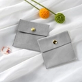 Grey microfiber jewelry pouch with gold snap button on white satin background - Microfiber Snap Button Style / 8*8cm / Light Gray