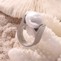 Anello chic in titanio argentato con una grande perla bianca su un corallo - US 6 / Color Acciaio