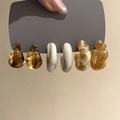 Close-up of acrylic C-shaped earrings in amber and marble patterns on a display card - 3-Pair Set: Amber/Beige