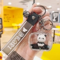 Detalle de llavero de panda con correa de cuero marrón y arena movediza negra líquida - Líquido Negro + Panda