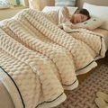 Thick cream fleece blanket with bubble texture shown in a cozy bedroom setting - Off-white