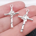 Silver cross pendants with rose and snake detail held in hand for jewelry making - Rose Wrapped 26x15mm (1.2g)