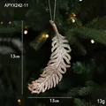 Glittery champagne gold feather Christmas ornament with hanging string on a festive tree - Feather Style