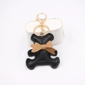 Cute black PU leather bear keychain with brown bow and gold metal ring on white background - Black