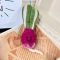 Handmade pink wool felt radish keychain with green leaves on newspaper pattern - Radish