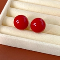 Dettaglio di orecchini di perle rosse su un espositore per gioielli in velluto beige - 1.7cm / Rosso