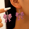 Detailed close-up of pink leopard print acrylic bow drop earrings on a model - Pink Heart Leopard Bow (01 White K DZ-944)