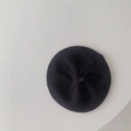 Top-down view of black knitted baby beret showing classic texture and pure color - Black