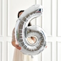 Large 40-inch silver number 6 foil balloon held by a model for birthday party decor - Silver Style 6